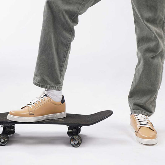 The Gold Standard beige low-top sneakers with a sleek, clean silhouette.